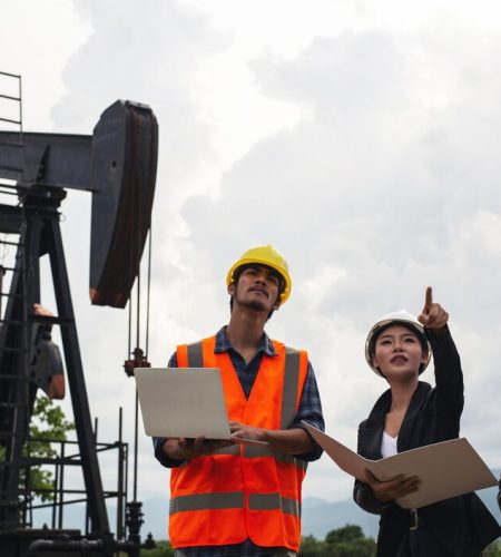 engineering-team-stands-beside-working-oil-pumps-with-sky_1150-19223